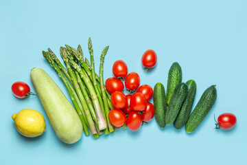 Fresh vegetables on a blue background. Crops. Zucchini, asparagus, tomatoes, cucumbers. The concept of proper nutrition. Flat lay.