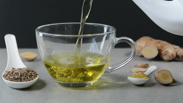 Cumin tea also known Jeera tea or Jeera water in a glass cup with cumin seeds in a spoon