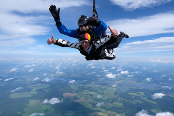 Fototapeta na wymiar Skydiving. Tandem jump. Two guys are flying in the sky.