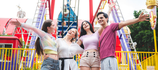 Group of happy best friends laughing and having fun at amusement park, holiday travel with friends concept