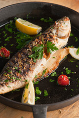 Branzino, whole grilled sea bream. Classic ethnic regional Greek  seafood favorite. Whole fish, grilled with skin in, served with lemon potatoes lemons Italian parsley and capers.