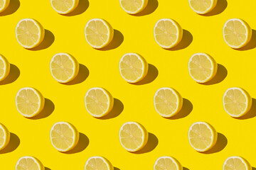 Minimal sunny summer flat lay fruit background. Fresh lemon slices on yellow background pattern