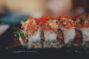 California roll topped with fresh salmon and salmon roe. Selective focus