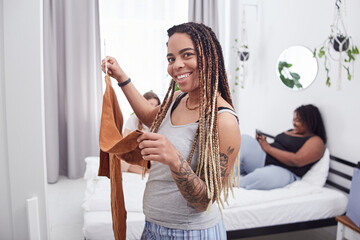 Cheerful Afro American female selecting the outfit for today