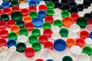 Close up of many colorful plastic bottle caps on white background. Stop plastic pollution concept