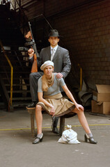 Two models get dressed up in 1930's style vintage 
clothing and act the part of the gangster duo 
Bonnie and Clyde. They are seen in the ruins of an 
old abandoned factory.