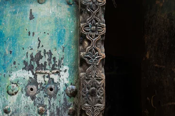 Gordijnen Zanzibar old green carved door. with aged detail texture. Great use in background.  © Robin