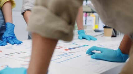 Asia businesspeople discussing business brainstorm meeting together share data, wearing face mask and glove back at work in new normal office. Lifestyle and social distancing at after coronavirus. - Powered by Adobe