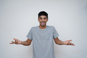 Young asian teen boy confused expression with a smile showing to the camera with white background.