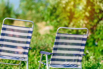 Two folding striped chairs for outdoor recreation
