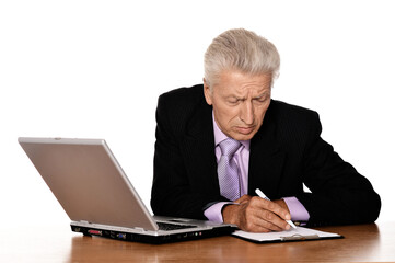 Portrait of old businessman working with laptop