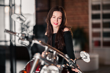 Fototapeta na wymiar Smiling Woman Sitting On Motorcycle Against Building
