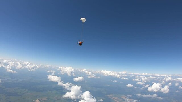 Skydiving. Tandem jump. A beautiful girl and her instructor are flying in the sky.