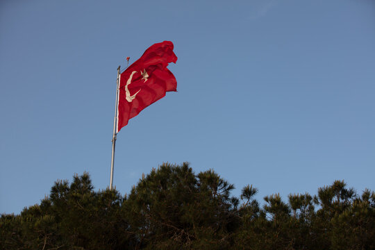 Turkish flag with red and white moon in blue sky