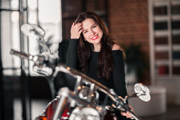 Fototapeta na wymiar Portrait Of Smiling Woman Sitting On Motorcycle Against Building