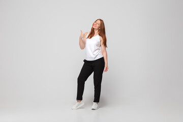 Thumb up. Young woman in casual wear on white background. Bodypositive character, feminism, loving herself, beauty concept. Plus size businesswoman during paperwork. Inclusion, diversity.