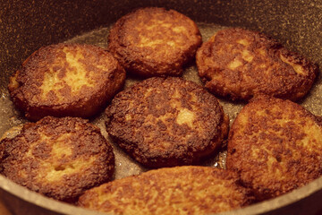 Fried potato cutlets in sunflower oil lie in a frying pan