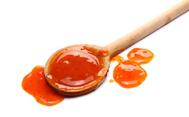 Chili sauce with wooden spoon isolated on white background