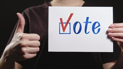 Vote sign. Perfect choice. Woman approving decision with thumb up hand gesture on blur dark background.
