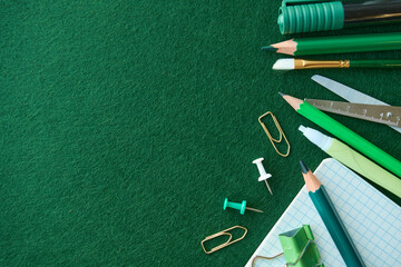 Stationery set on green background. School supplies top view for advertising and promotional items. Back to school concept