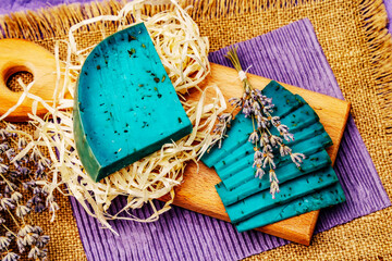 Dutch blue cheese with lavender. Piece and slices, dry fragrant flower, cutting board