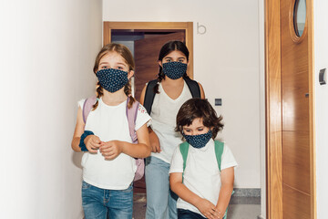 three brothers going to school wearing masks
