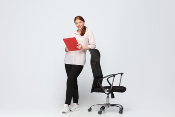 Working with documents. Young woman in casual wear on white background. Bodypositive character, feminism, loving herself, beauty concept. Plus size businesswoman during paperwork. Inclusion, diversity