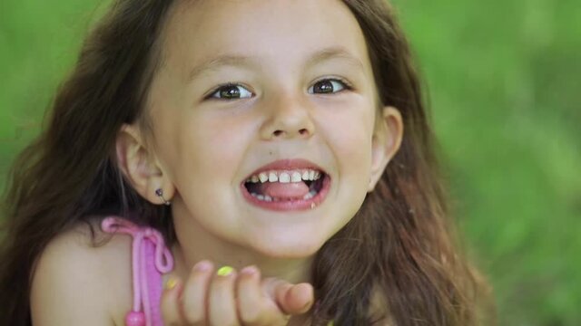 The little girl makes faces and points her tongue at the camera.
