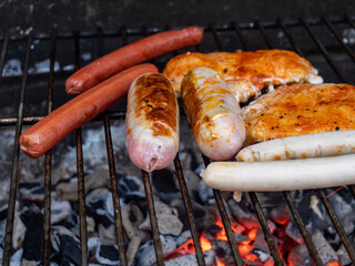 Grillsortiment auf dem Holzkohlegrill im Garten