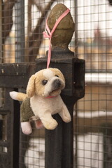 Fluffy puppy toy left on the fence. Homeless, helpless