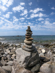 Fototapeta na wymiar stone pyramid by the ocean. stone tower by the water