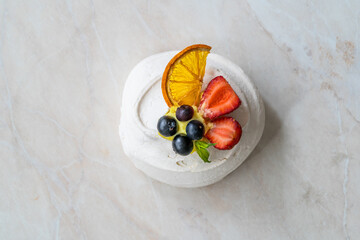 Meringue Dessert Pavlova Cake with Fresh Berries, Strawberries and Dried Orange Slice.