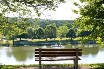 The empty bench with a view of the lake in the park.