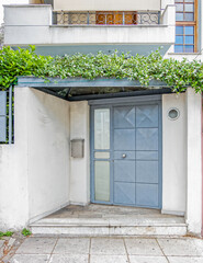 Fototapeta na wymiar modern family house entrance grey door with green foliage, Athens Greece