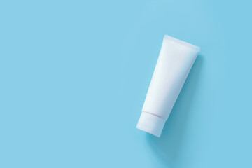 Cosmetic bottle container on a pastel blue background. Top view of mockup of white squeeze bottle...