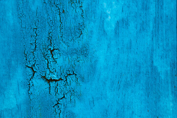 Dark blue wooden background. Board with the texture of old cracked paint with smudges of resin.