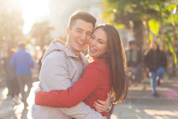 Couple hugging in a city street, lens flare