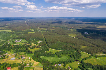 Fototapeta na wymiar Aerial view of cloudy sunny day. Countryside surrounded by green fields, rivers and trees.