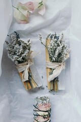Overhead shot of beautifully arrange smudge sticks on white wrapping paper