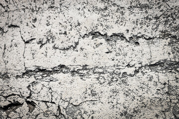 Cracked cement wall with old white paint. Exterior facade grunge texture copy space background concept.