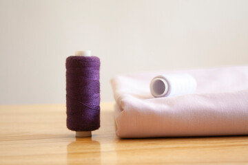 
a piece of fabric and thread for sewing on the table