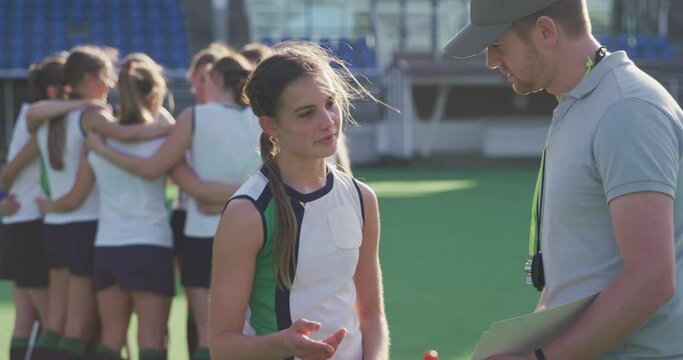 Hockey Coach Talking With Female Player On The Field 