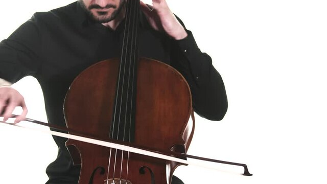 masterly musician in a black shirt performs a beautiful slow melody on a classical cello. Isolated. Medium long shot