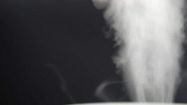 White steam of ultrasonic humidifier. Frume of vapor from diffuser for air moisturize. Loop endless video of smoke for humidity at home. Moisturizer and purifier of air. Diffused mist from inhaler.