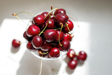 sweet cherries in a glass bowl on a bright white surface