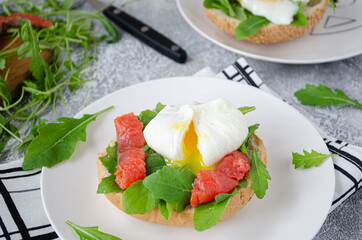 Toast with poached egg, salmon and arugula