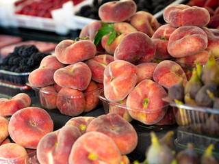 Fresh bio peaches. Flat Fig peach at the street farmer's market. Still life side view