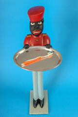 Statue of a black servant with a brush on the tray