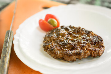 Cooked minced beef hamburger patty on a plate