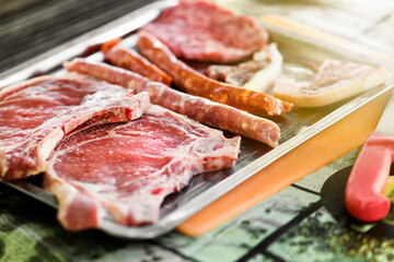 Rib eye steaks and spicy sausage ready to barbecue